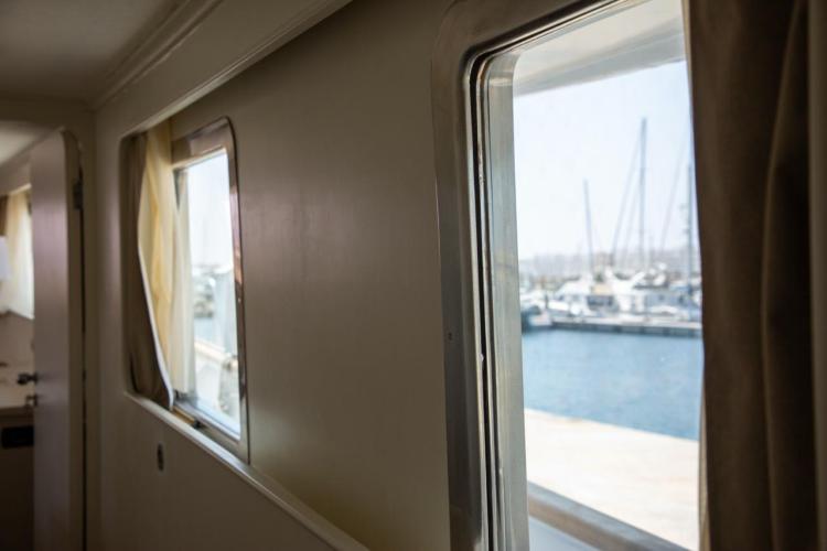 Interior view of 1972 Benetti 33 yacht with marina visible through window.