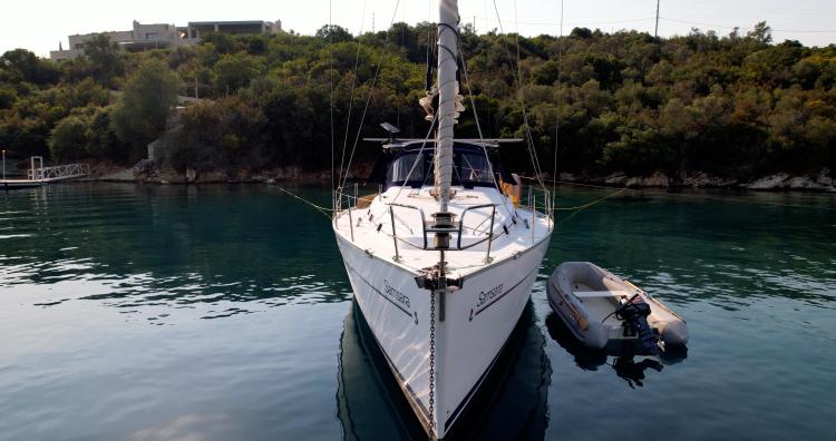 2005 Beneteau Cyclades 43.3 sailboat docked in serene waters with lush greenery.