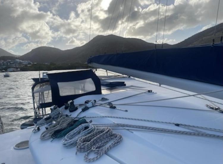 2009 Fountaine Pajot Orana 44 catamaran with ropes on deck, scenic mountain backdrop.