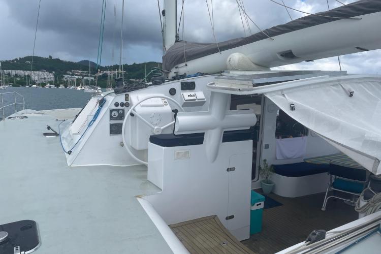 Sailboat deck view with steering wheel, Custom KSENIA 149, 2010 model, moored in marina.