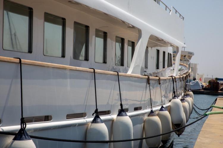 1972 Benetti 33 yacht docked with fenders, side view.