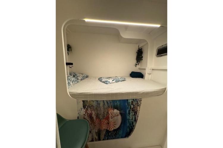 Cozy cabin interior of 2004 Etoile Marine Maxi Cat 24 with bed and decorative elements.