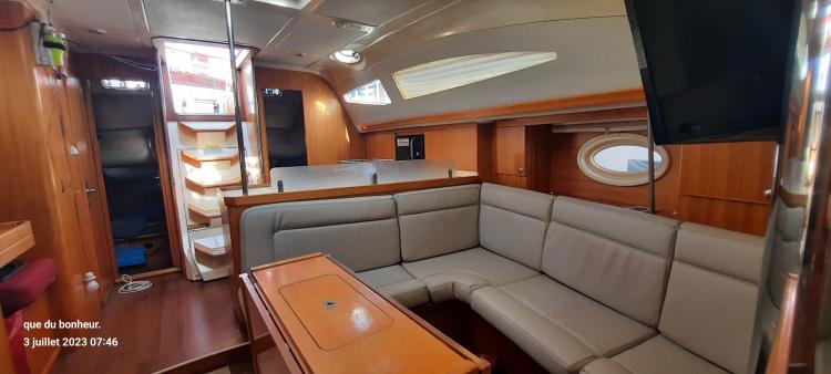Spacious interior of 2007 Elan Impression 434 yacht with comfortable seating and wooden finishes.