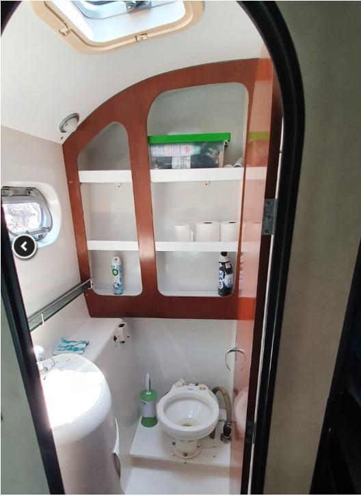 Bathroom interior of 1999 Fountaine Pajot Bahia 46 catamaran, featuring shelves and a porthole.
