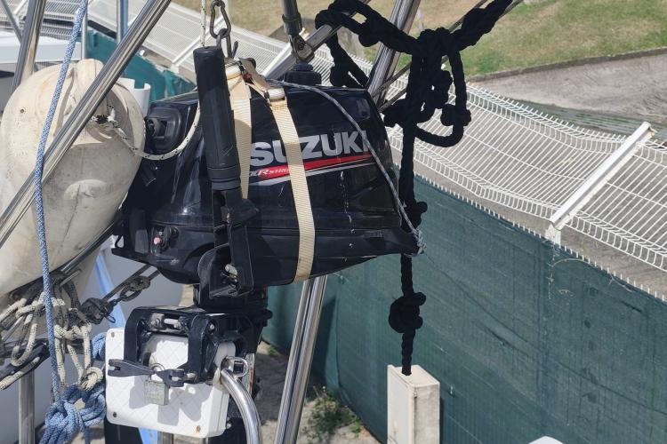 Suzuki outboard motor secured on Jeanneau Sun Odyssey 37 sailboat, year 2000.