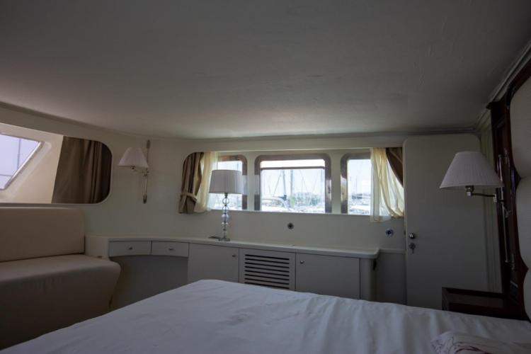 Interior of a 1972 Benetti 33 yacht, featuring elegant furnishings and large windows.