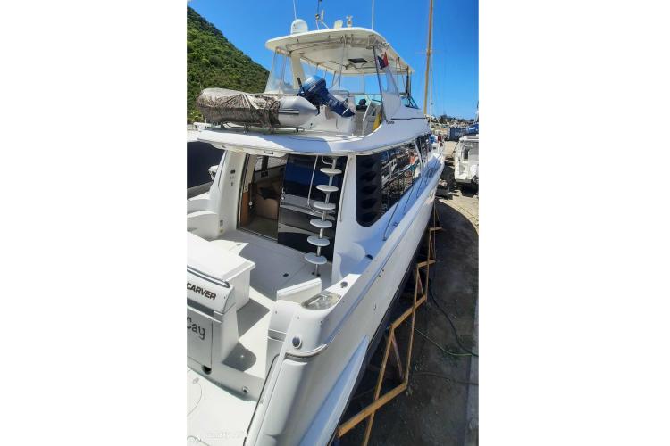 Carver 530 Voyager Pilothouse 2000 yacht docked, showcasing sleek design and spacious deck.