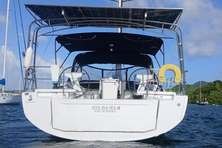 2019 Beneteau Oceanis 46.1 sailboat with solar panels, anchored in scenic waters.