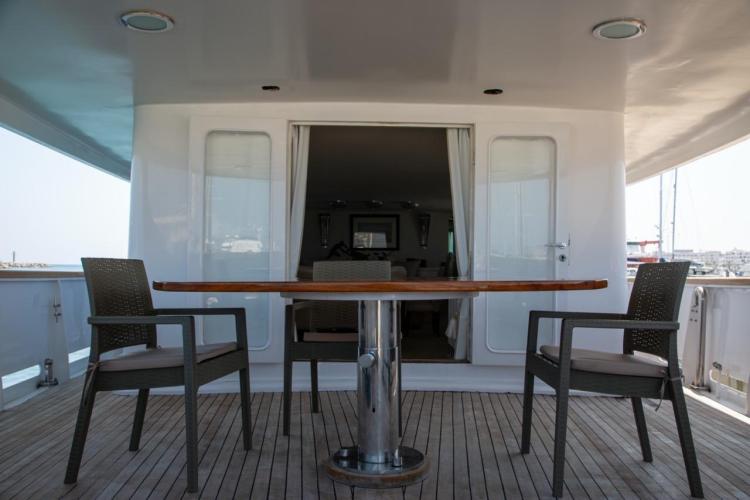 Deck view of 1972 Benetti 33 yacht with table and chairs.