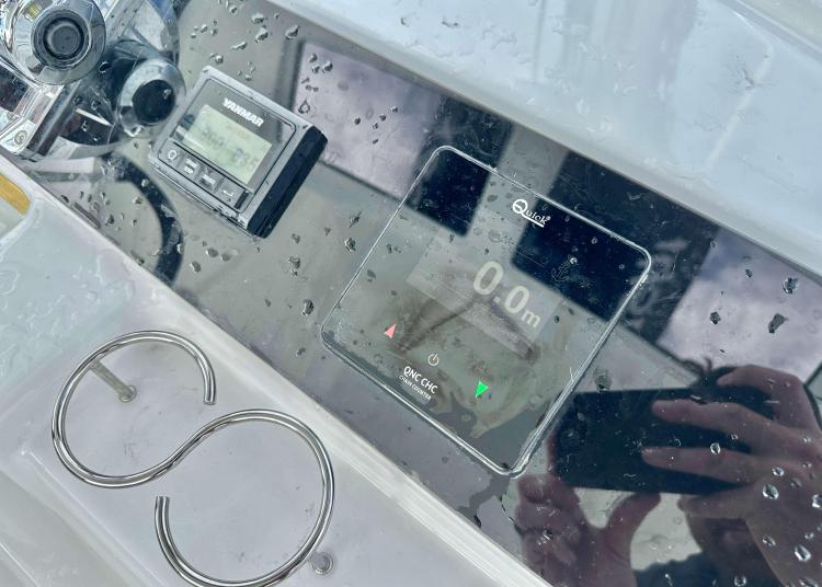 Control panel of 2023 Lagoon 46 yacht with digital displays and raindrops.