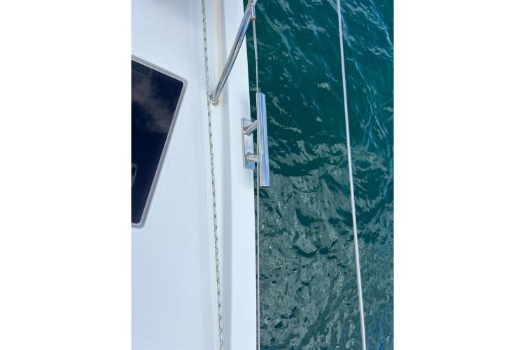 Close-up of 2023 Fountaine Pajot Astrea 42 Catamaran deck and railing over water.