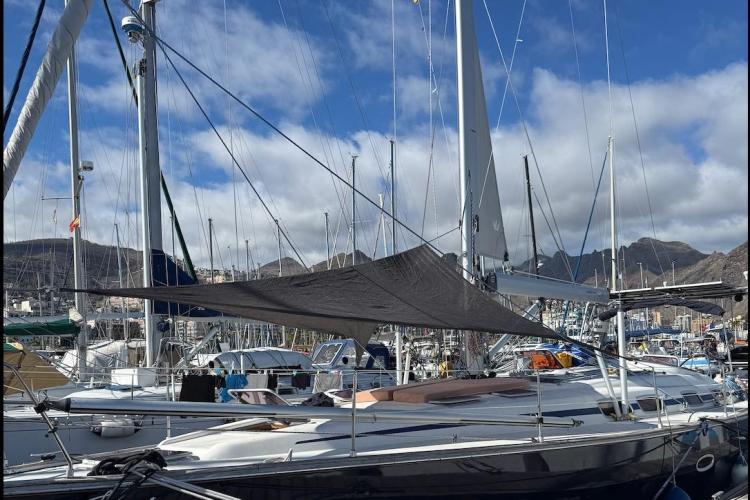 2006 Bavaria Cruiser 46 sailboat docked in a marina with mountains in the background.