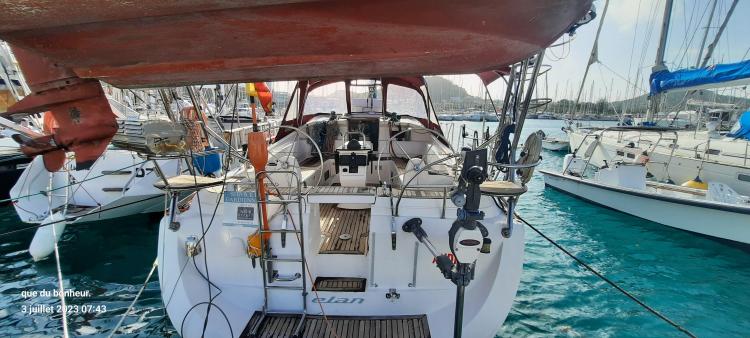 2007 Elan Impression 434 yacht docked in a marina, surrounded by clear blue water.