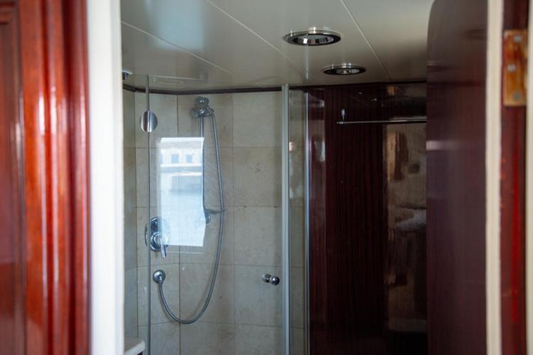 Shower area in 1972 Benetti 33 yacht with glass door and tiled walls.