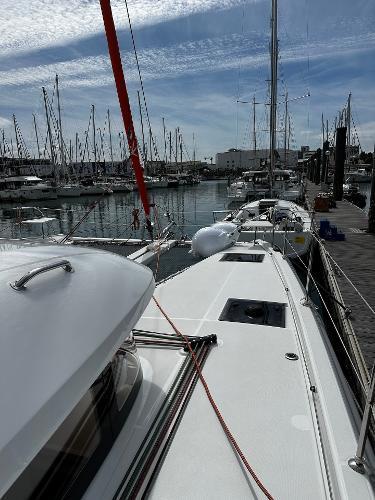 2024 Excess 11 yacht docked at a marina with clear skies and sailboats.