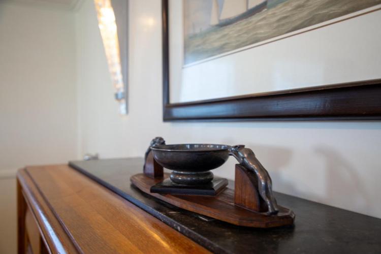 Decorative bowl on Benetti 33 yacht, 1972, with nautical artwork in background.
