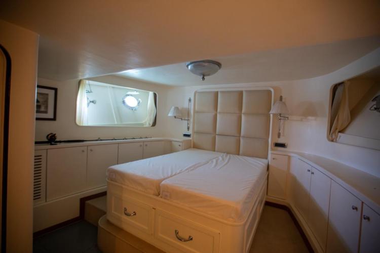 Luxurious bedroom interior of 1972 Benetti 33 yacht with elegant furnishings.