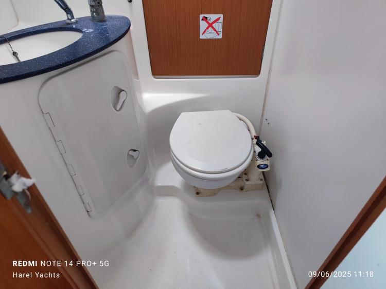 Bathroom interior of 2005 Beneteau Cyclades 43.3 yacht, featuring toilet and sink.