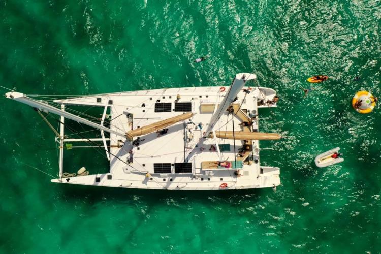 Aerial view of Etoile Marine NAUTILUS 360 yacht, 2004, surrounded by turquoise water and swimmers.