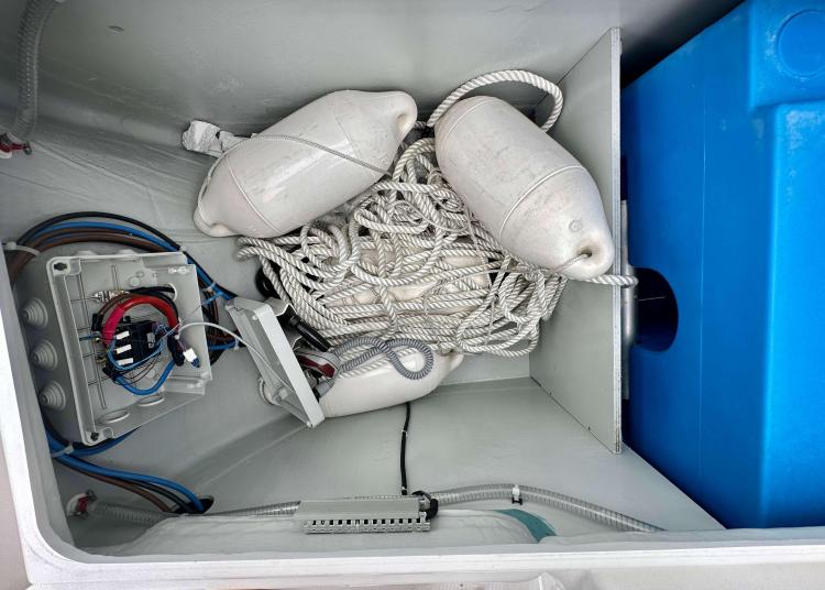 Storage compartment of 2023 Lagoon 46 with ropes, fenders, and electrical components.