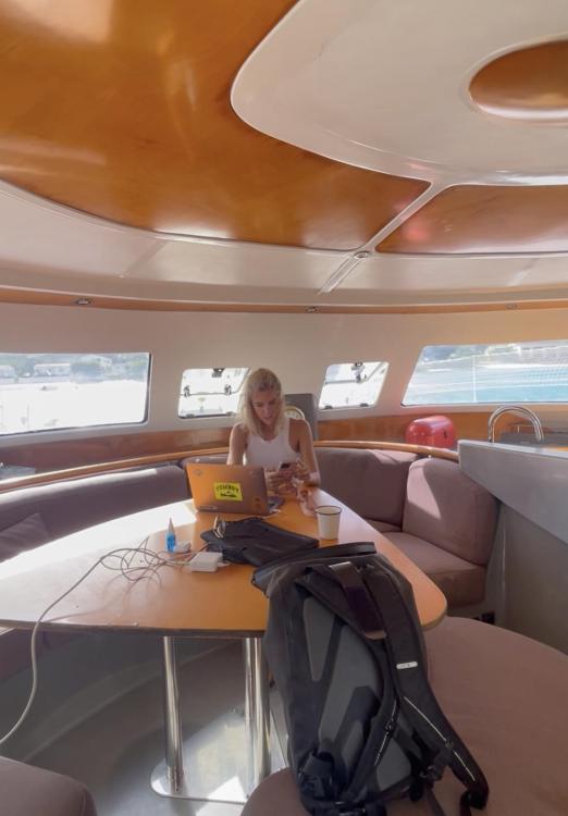 Interior of 2006 Fountaine Pajot Bahia 46 catamaran with person working on a laptop.