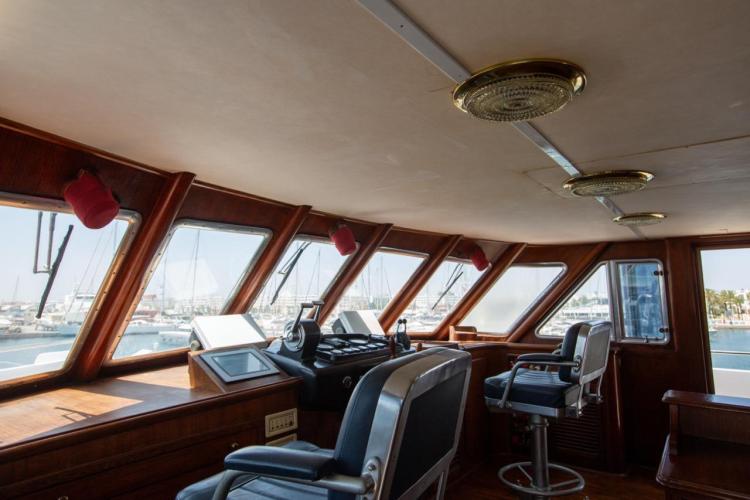 Interior view of 1972 Benetti 33 yacht's helm with panoramic windows and classic design.