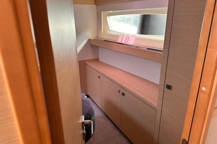 Interior cabin of 2016 Fountaine Pajot Ipanema 58 yacht with wooden cabinetry and window.