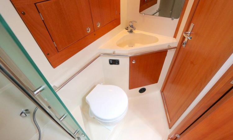 2007 Elan Impression 434 yacht bathroom with wooden cabinets and compact fixtures.