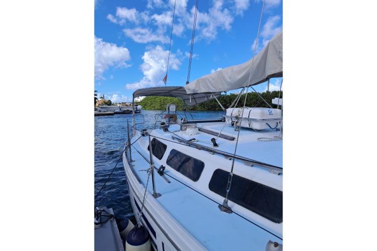 1986 Dufour CATALINA sailboat on calm water under blue sky.