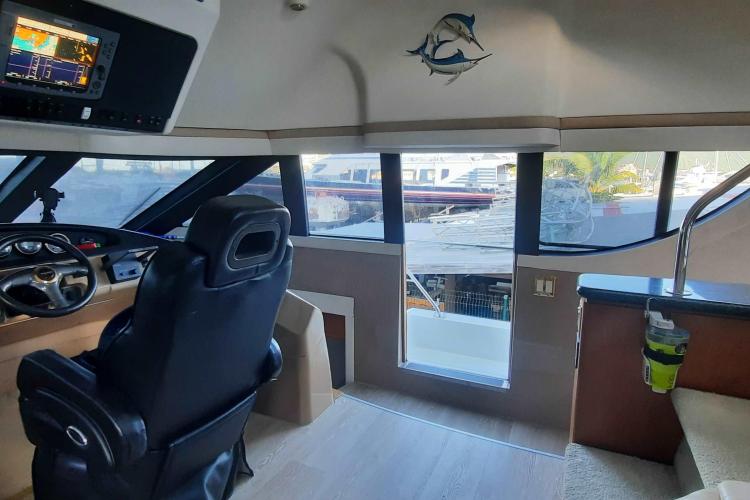 Interior of 2000 Carver 530 Voyager Pilothouse with helm and panoramic windows.
