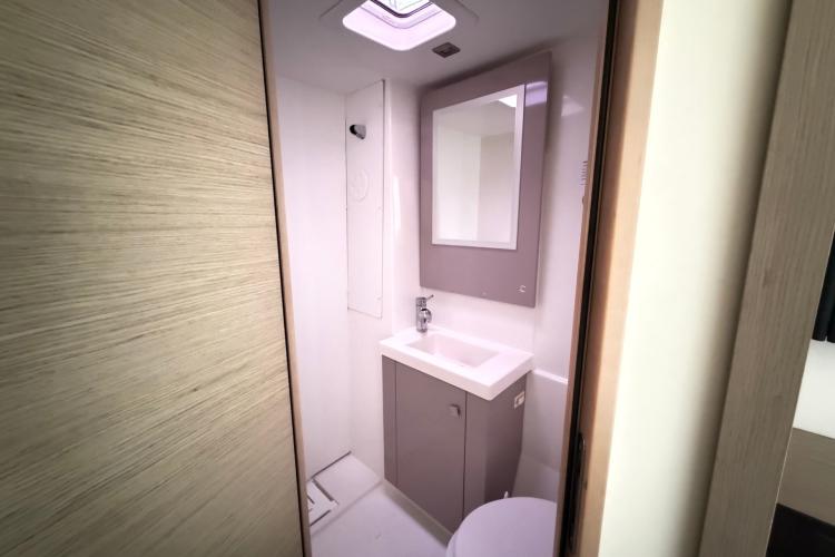 Modern bathroom interior on 2020 Fountaine Pajot Astrea 42 yacht, featuring sleek sink and mirror.