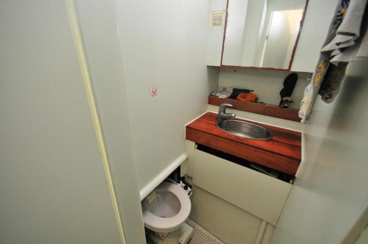 Compact bathroom in 2005 Custom Polynésie 42 boat with sink and toilet.