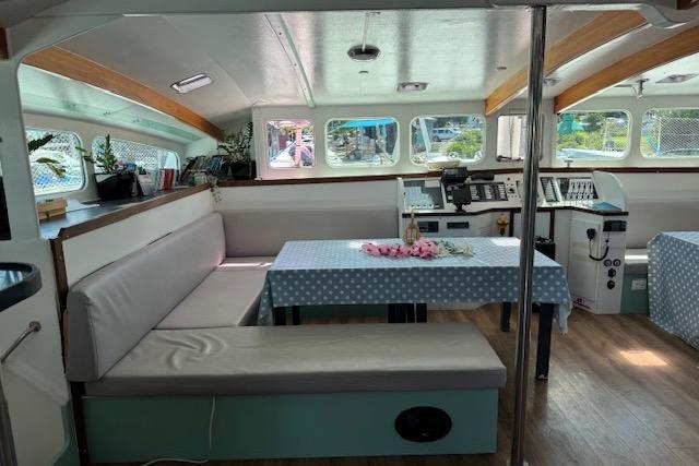 Interior of 2004 Etoile Marine Maxi Cat 24 catamaran with seating, tables, and navigation equipment.