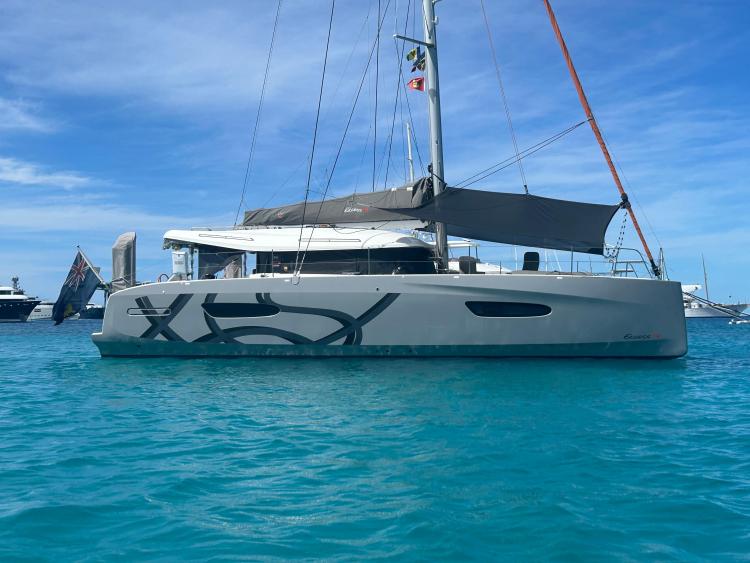 2024 Excess 14 catamaran sailing on clear blue water under a bright sky.