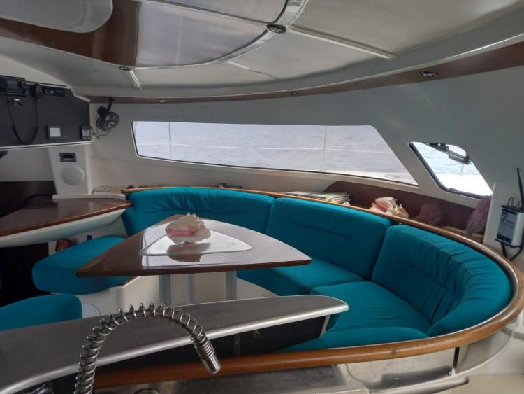 Interior of 1999 Fountaine Pajot Bahia 46 catamaran with blue seating and dining area.