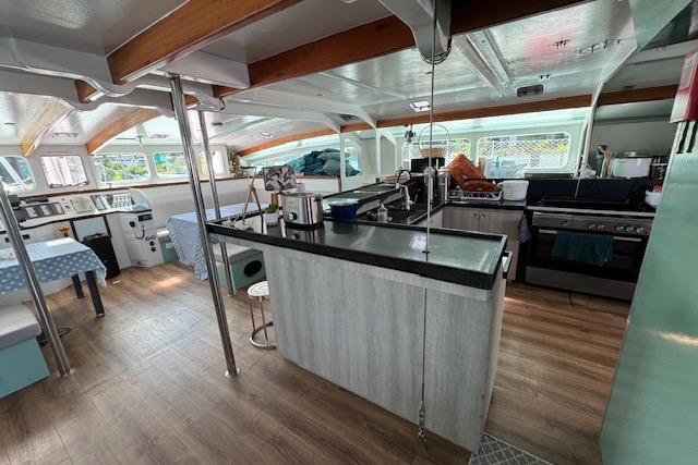 Spacious interior of 2004 Etoile Marine Maxi Cat 24 catamaran with modern kitchen and dining area.