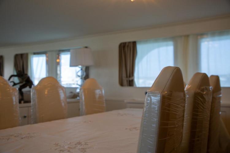 Interior of 1972 Benetti 33 yacht with elegant dining area and large windows.