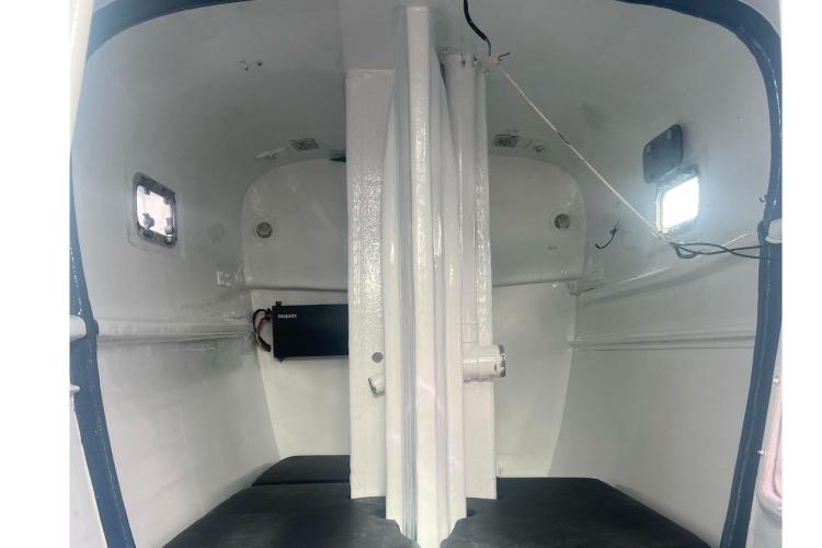 Interior of a 1994 Coulombel Trimaran, featuring compact cabin space with windows.