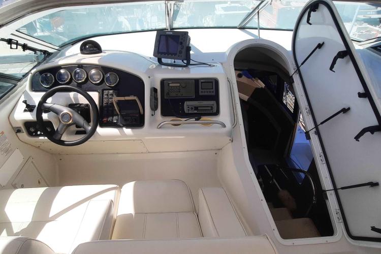 Interior of 2000 Carver 530 Voyager Pilothouse with steering wheel and navigation equipment.