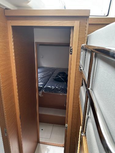 2024 Excess 11 yacht interior with wooden door and cozy sleeping area.