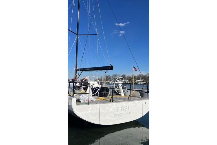 2024 Beneteau First 53 sailboat docked, featuring dual steering wheels and sleek design.