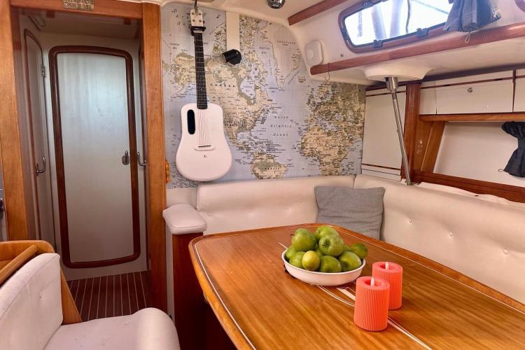 Cozy Bavaria Cruiser 46 yacht interior with map, guitar, and fruit bowl, 2006 model.