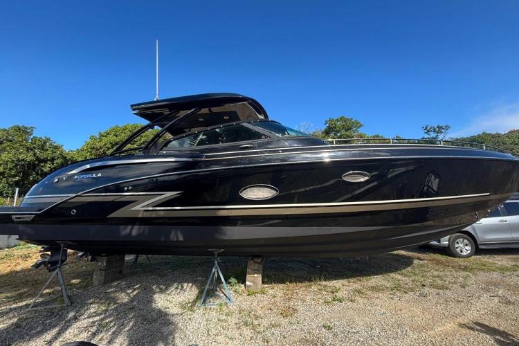 2018 Formula 350 Crossover Bowrider boat on display, sleek black design, sunny day.