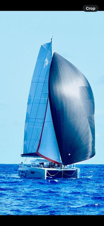2024 Excess 14 catamaran sailing on open ocean with full sails.