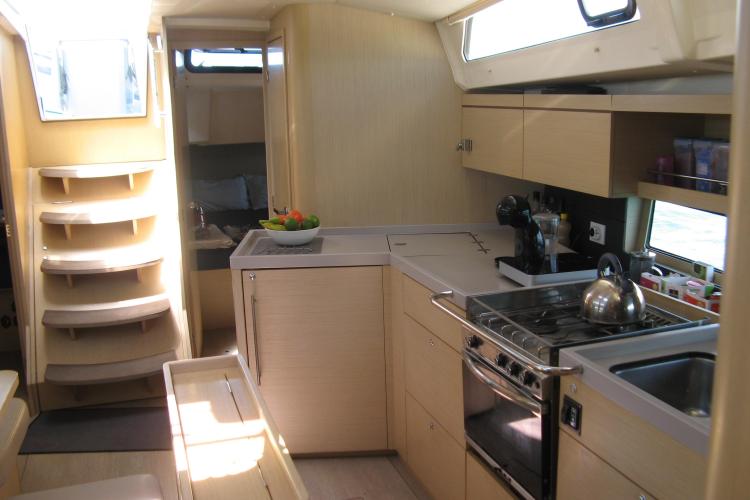 Interior of 2019 Beneteau Oceanis 46.1 yacht, featuring modern kitchen and stylish wooden cabinetry.