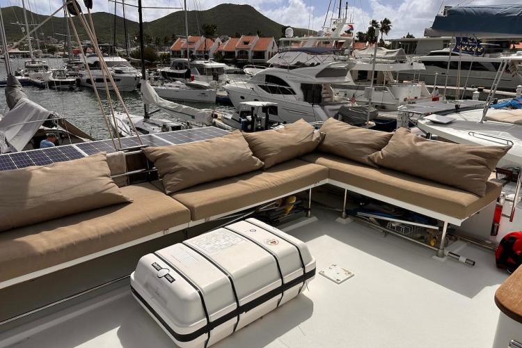 2016 Fountaine Pajot Ipanema 58 yacht with cushioned seating, docked in a marina.
