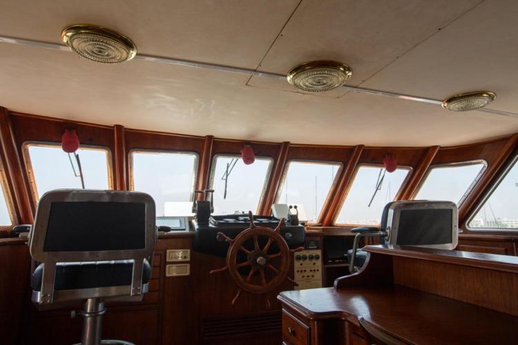 Bridge interior of 1972 Benetti 33 yacht with steering wheel and navigation equipment.