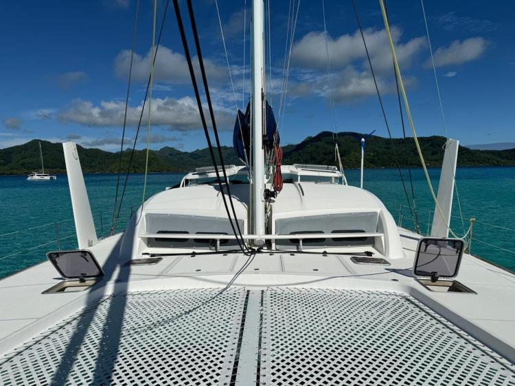 Catana 55 catamaran sailing in turquoise waters, 2012 model, with scenic island backdrop.