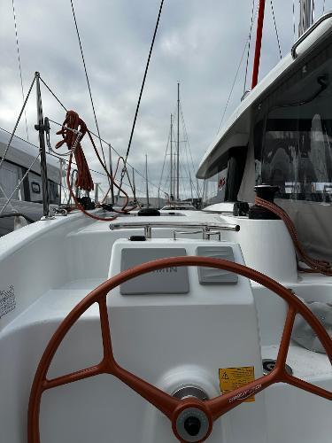 2024 Excess 11 sailboat cockpit with steering wheel, ropes, and overcast sky.