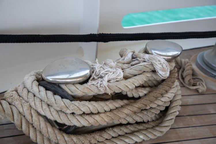 Coiled rope on deck of 1972 Benetti 33 yacht, featuring polished cleats.
